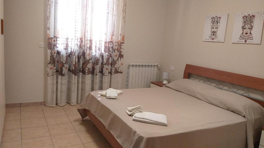 una camera da letto con un letto e due asciugamani di Dabliu House a Torrenova