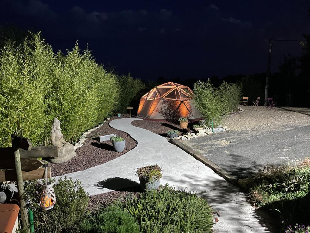 ein Gewächshaus in einem Garten in der Nacht mit einer Straße in der Unterkunft Le Dôme et son jacuzzi in Grazac