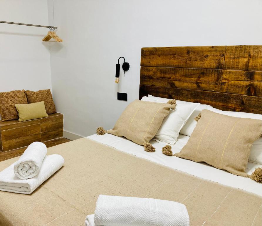 um quarto com uma cama grande com lençóis brancos e almofadas em LUXURY, PRIVATE WELLNESS IN PRADO MUSEUM NEW AUG21 em Madri