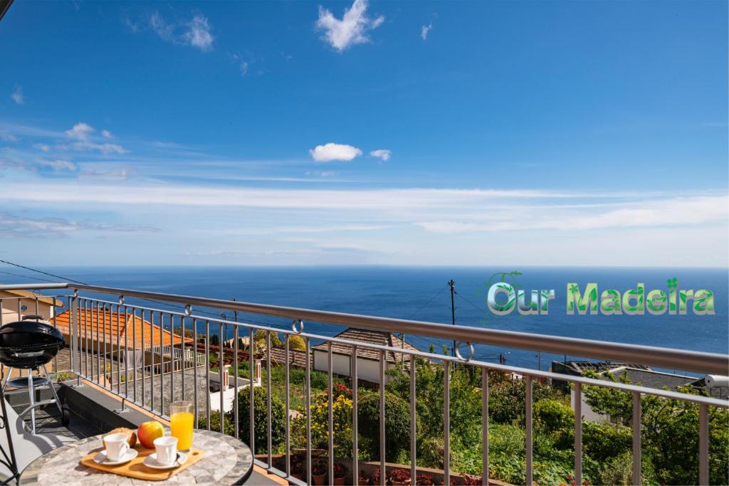 balcón con mesa y vistas al océano en OurMadeira - SeaView Apartment, countryside, en Calheta