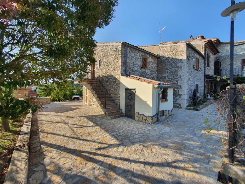 a stone house with a staircase on a street at B&B Fontanelle in Alviano