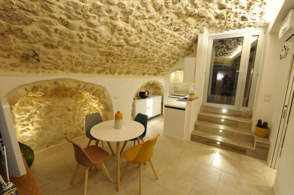 ein Esszimmer mit einem Tisch und Stühlen sowie einer mit Algen bedeckten Decke in der Unterkunft Pietrabianca Santa Maria Apartments in Manfredonia
