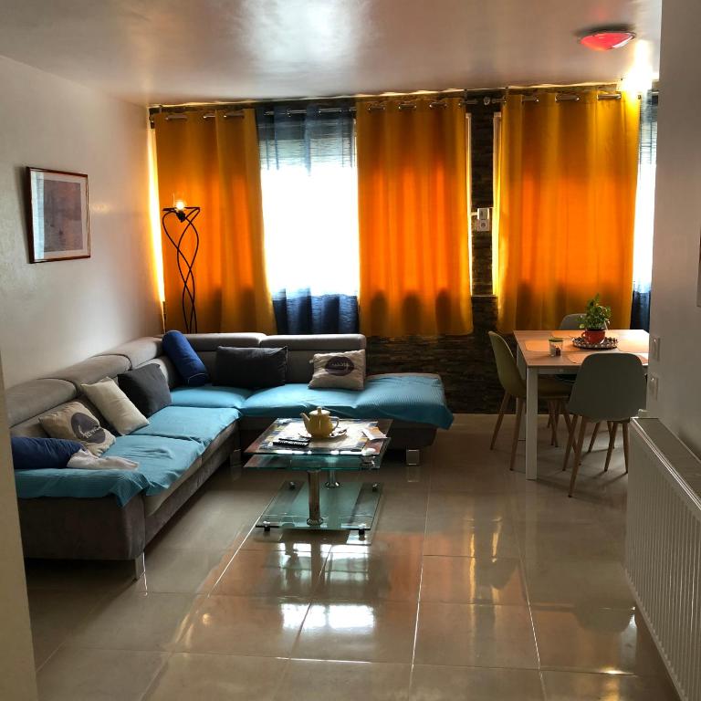 un salon avec un canapé bleu et une table dans l'établissement T3 Centre Ville Neuve, à Tarbes