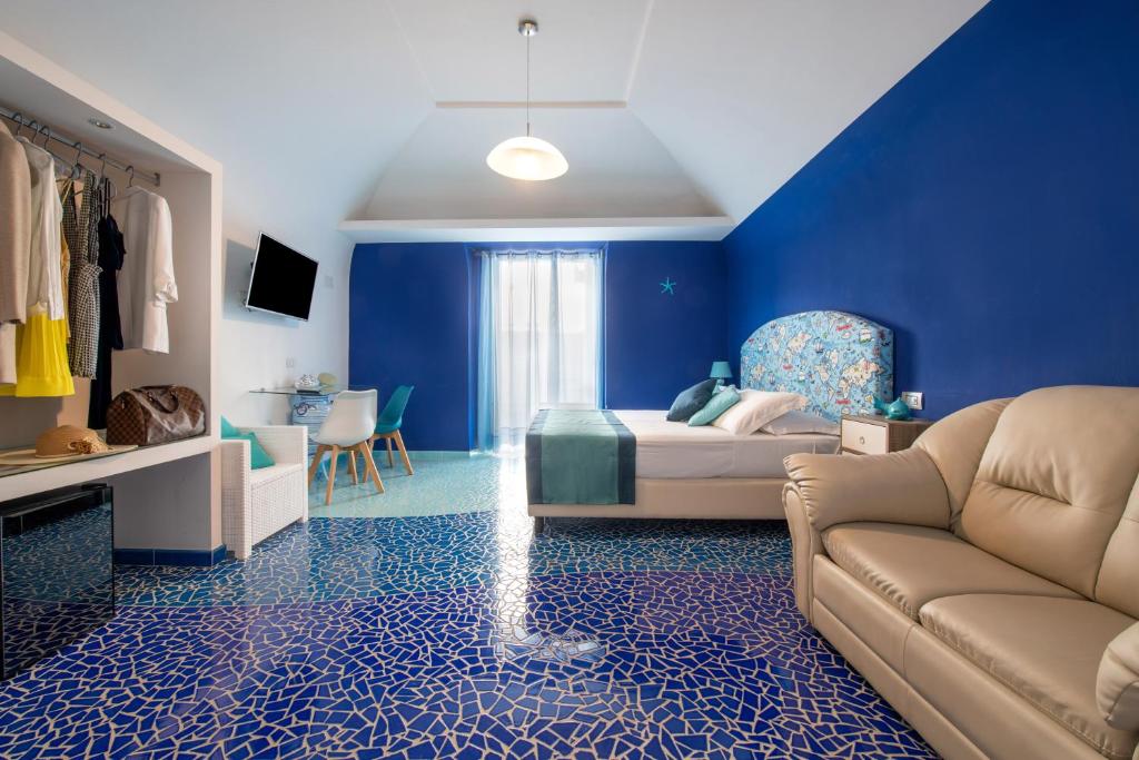 een blauwe kamer met een bank en een bed bij Aquae Romanae in Sorrento
