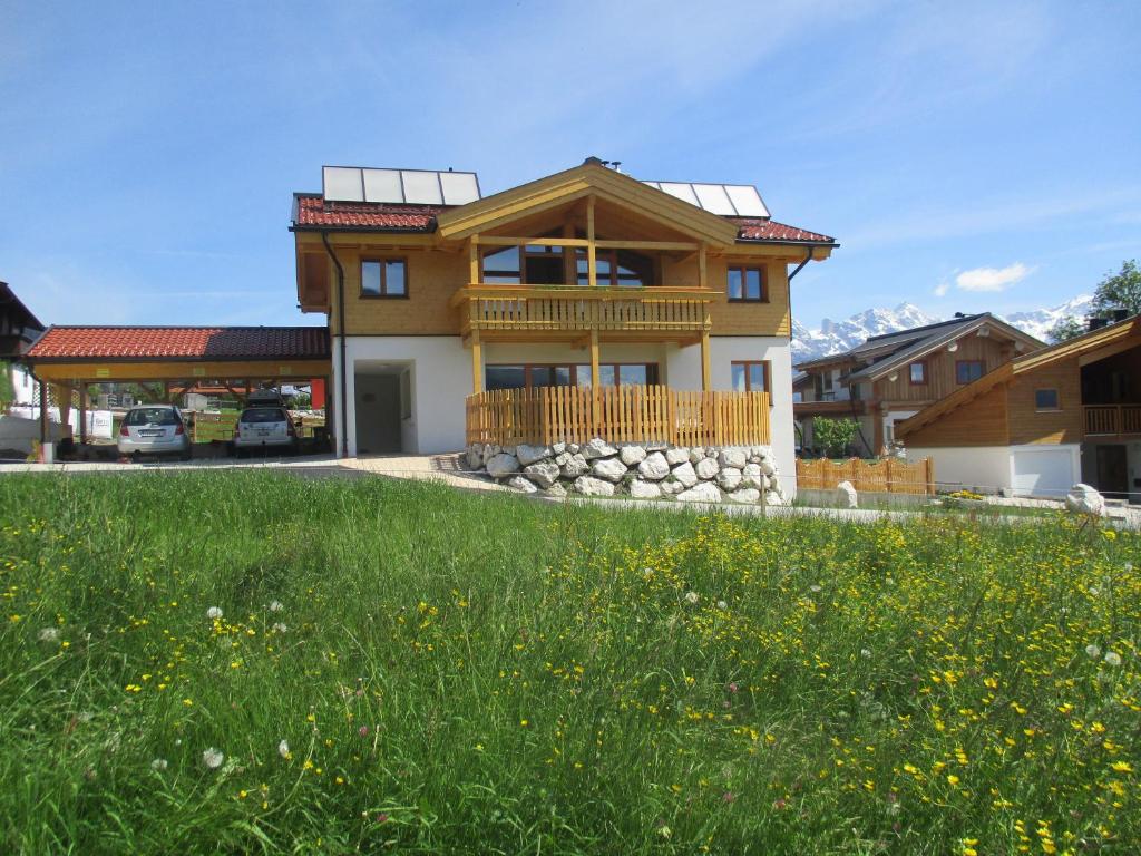 ein Haus mit einem grünen Feld davor in der Unterkunft Villa Mandl mit Garten Sauna Pool in Maishofen