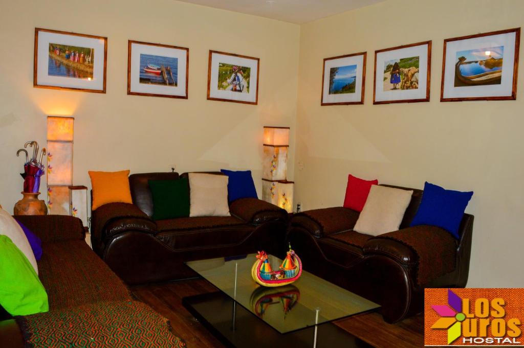 Sala de estar con 2 sofás y mesa en Hostal los Uros, en Puno