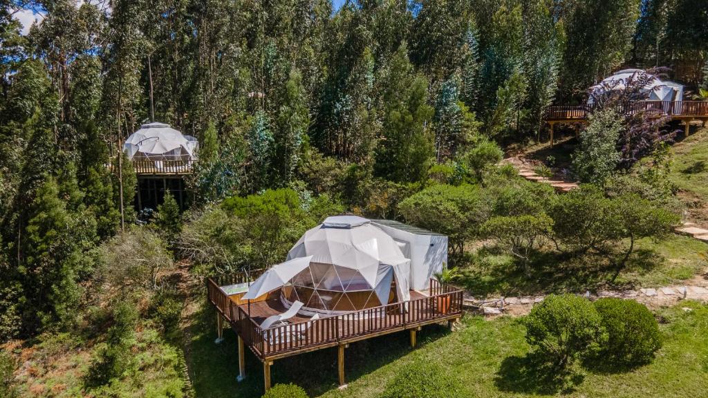 a gazebo on a deck with a train in the background at TERRA LUNA GLAMPING in Paipa