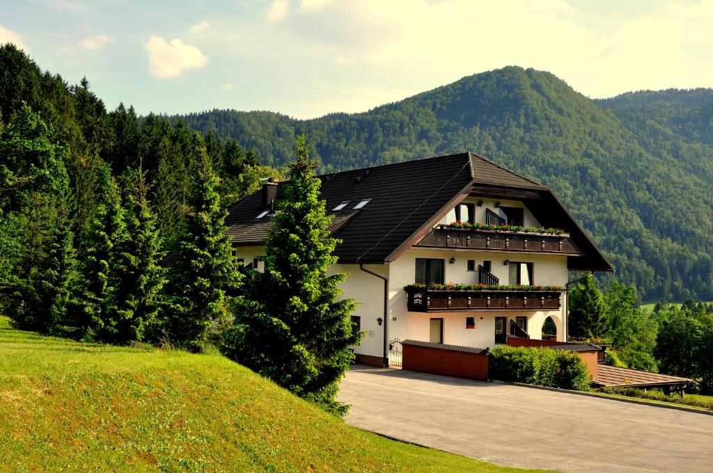 a house in the middle of a hill with trees at Nature Hotel Lukanc in Bled