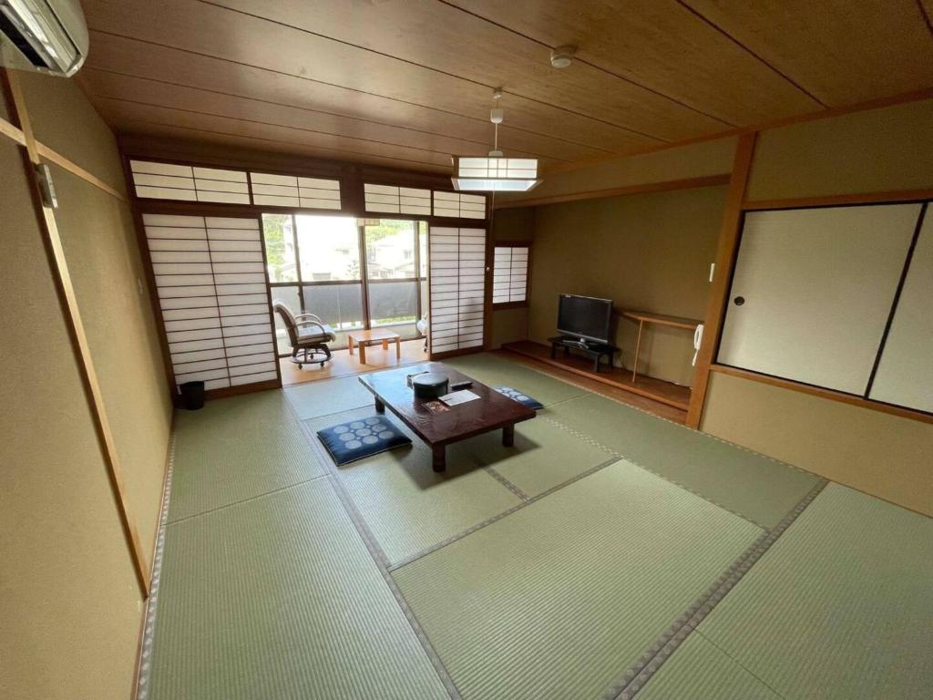 a living room with a table and a tv at Iso Tokei - Vacation STAY 61860v in Kanayama