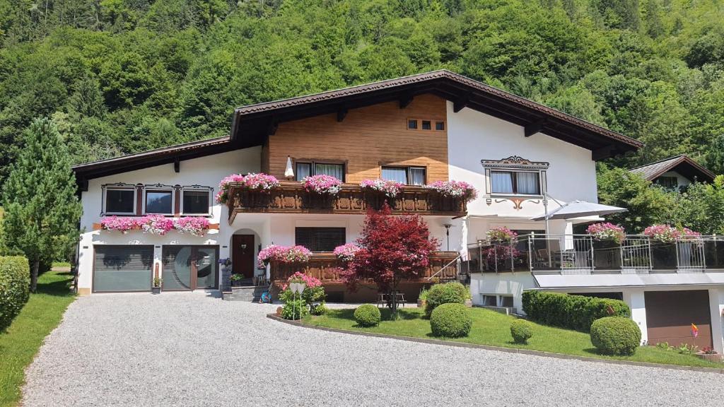 une maison avec des fleurs sur ses balcons dans l'établissement Appartement Landhaus Einsiedler, à Sankt Gallenkirch