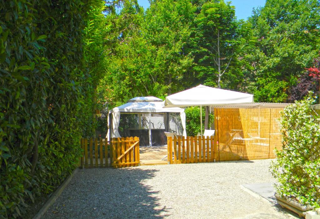a fence with a white tent in a yard at Hotel Villa Serena in Castrocaro Terme