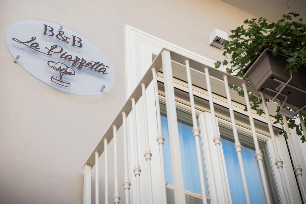 una puerta blanca con una señal en el lateral de un edificio en B&B La Piazzetta en Pompei