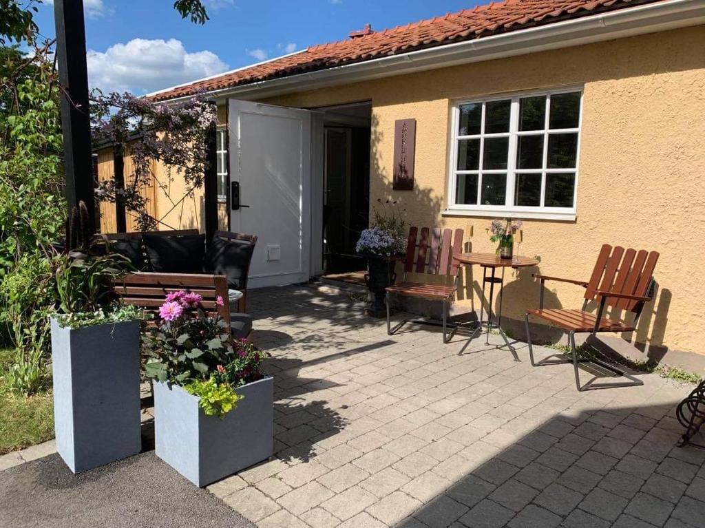 a patio with a table and chairs and a house at Bästa läget i Kalmarsundsparken in Kalmar