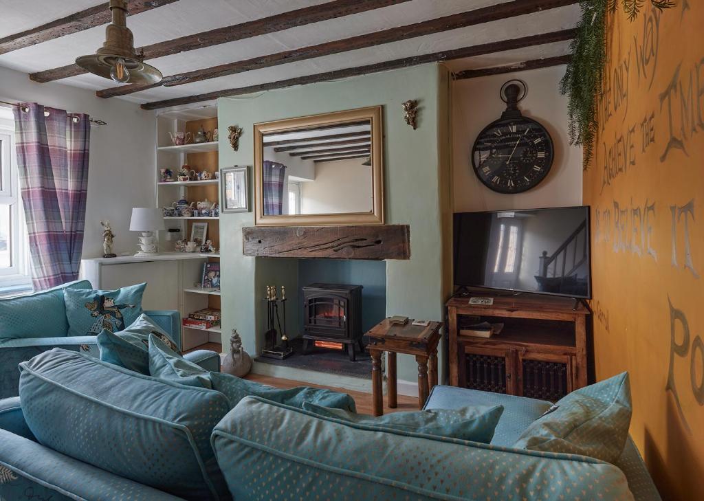a living room with a blue couch and a television at Violets Wonderland Cottage in Llandudno