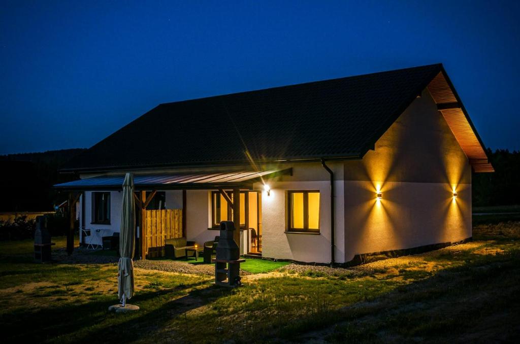 a small house with lights on the side of it at Zagroda Wataha 782 305 923 in Polańczyk