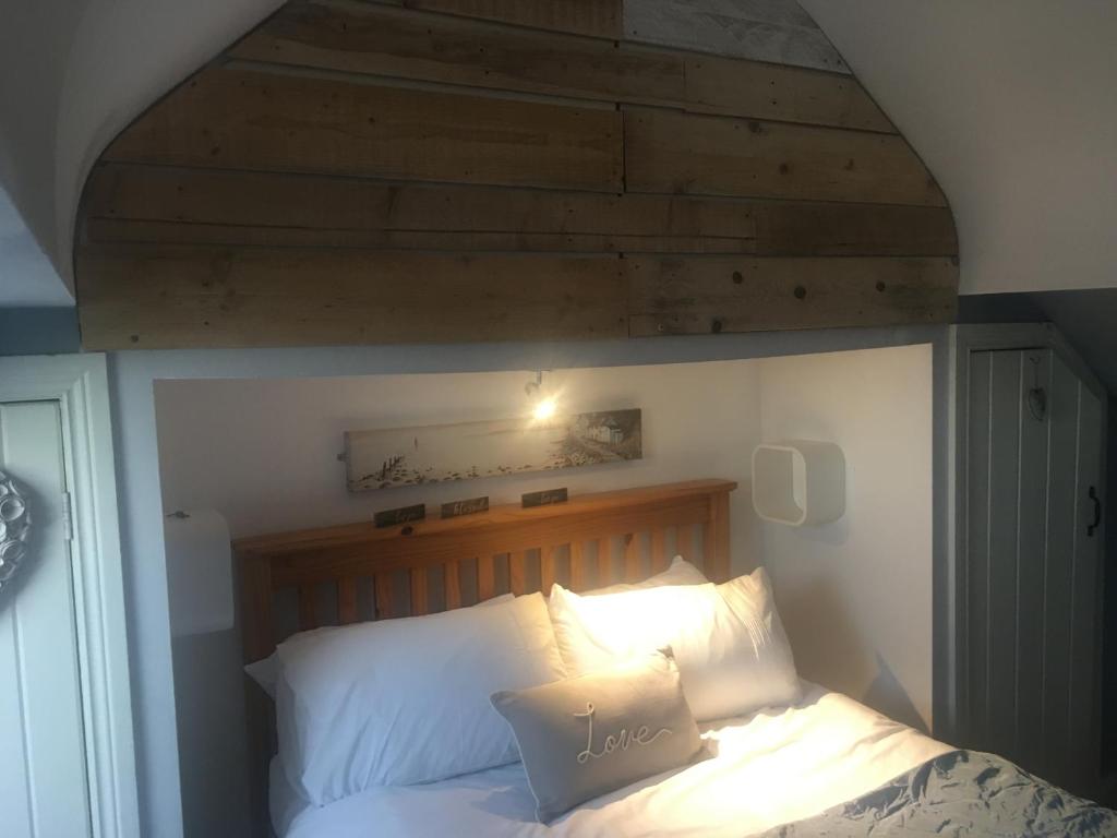ein Schlafzimmer mit einem Bett mit einem Kopfteil aus Holz in der Unterkunft Driftwood Loft in Killyleagh