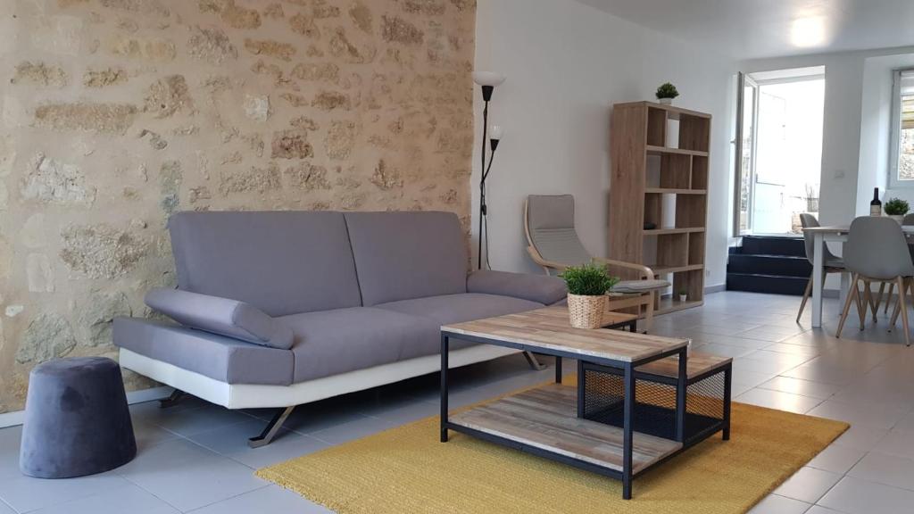 a living room with a couch and a table at Nathan Home in Saint-Jean-de-Blaignac