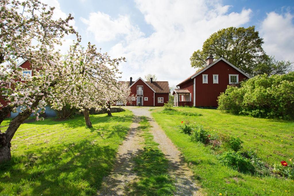 un camino de tierra delante de dos casas rojas en Lilla Sörgården, en Kungsberga