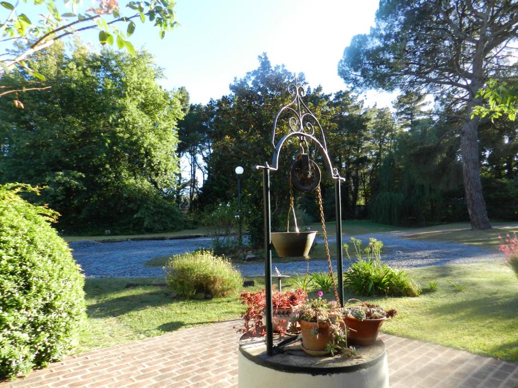 a garden with a flower stand with potted plants at Casa de Campo Las Acacias in Tandil