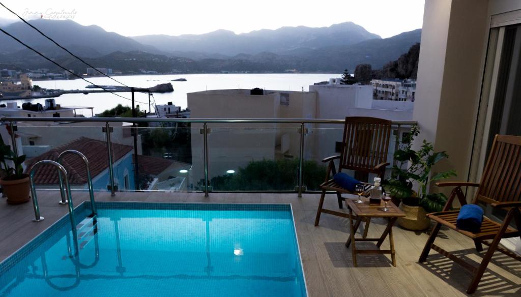 einen Balkon mit Pool und Blick auf das Wasser in der Unterkunft Sunset brand new luxury apt with pool & sea view in Karpathos