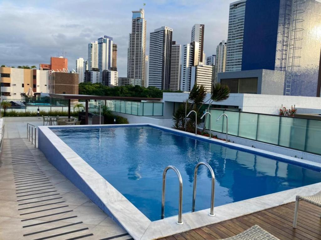 una piscina en la azotea de un edificio con vistas al perfil urbano en APARTAMENTO TEMPORADA - CABO BRANCO, en João Pessoa