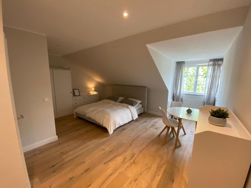 a bedroom with a bed and a desk and a table at Ferienwohnung Pelzerhaken in Pelzerhaken