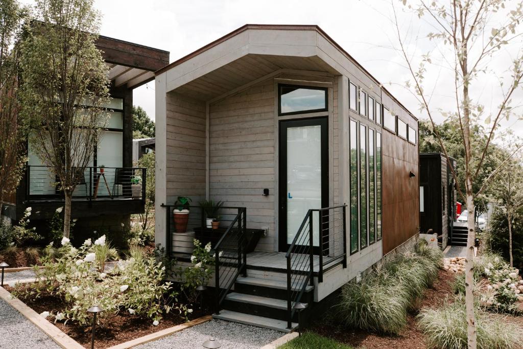 Una pequeña casa con porche y escaleras. en Ironwood Grove, Tiny House Hotel, en Nashville