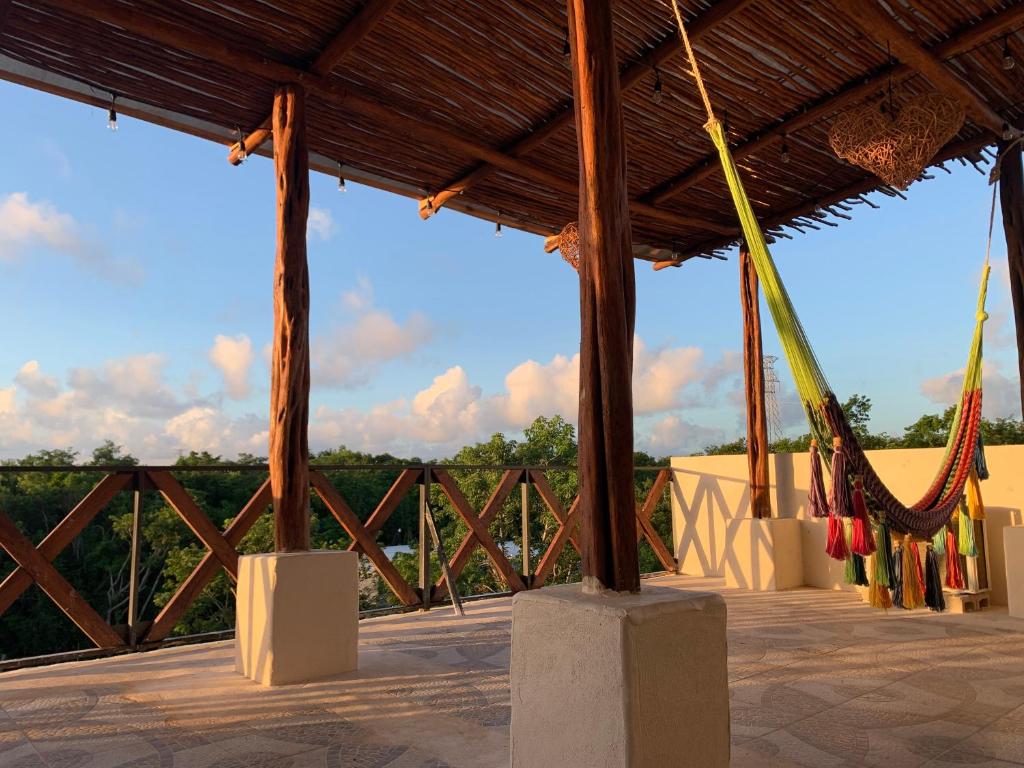 a pavilion with a wooden roof with hammocks at Casa Delfín Tulum in Macario Gomez