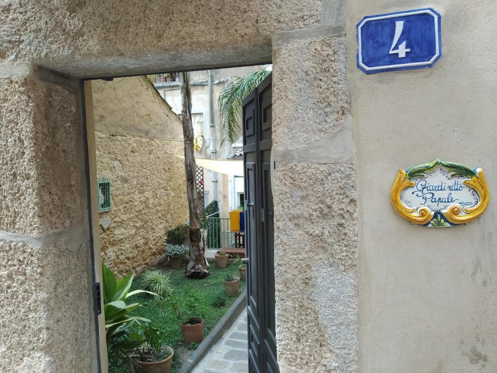 ein Schild an der Seite eines Gebäudes in der Unterkunft Giardinetto Papale, centralissimo in Caltagirone