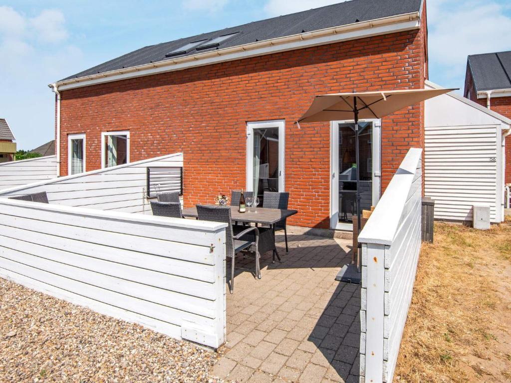 a patio with a table and an umbrella at Apartment Rømø XXXI in Sønderby