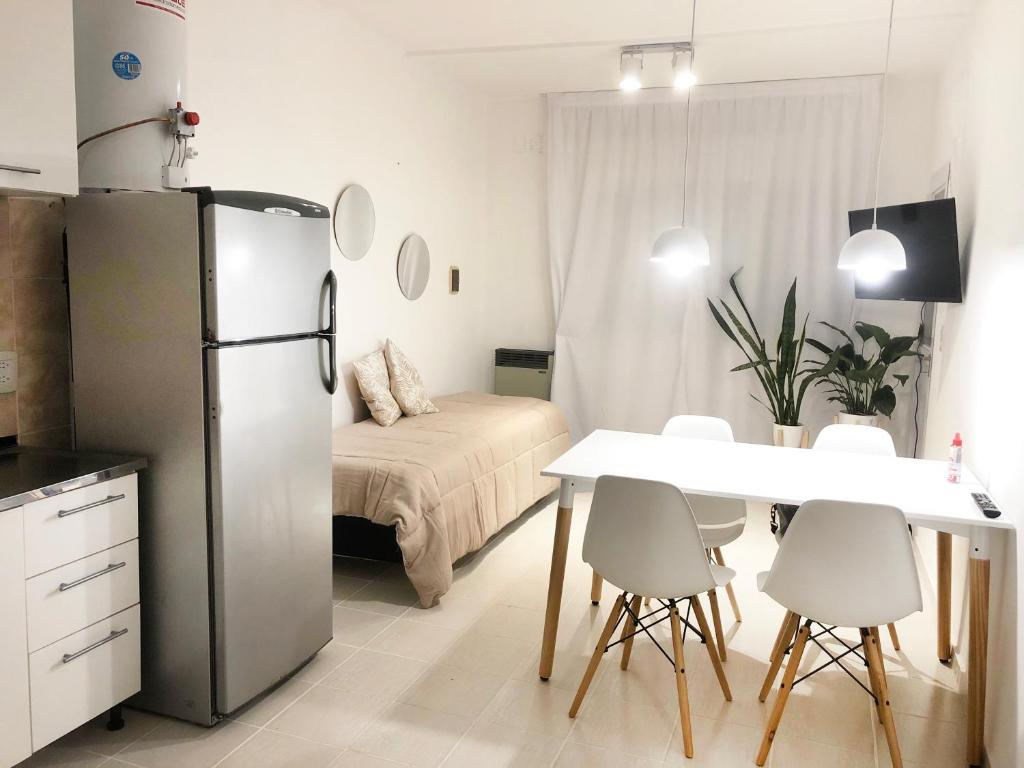 eine Küche und ein Esszimmer mit einem Kühlschrank und einem Tisch in der Unterkunft RIO 1 Departamento temporario con cochera in Villa María