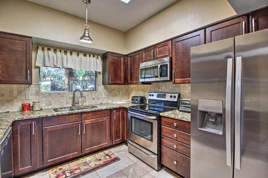 uma cozinha com armários de madeira e electrodomésticos de aço inoxidável em Relaxing Green Valley Townhome about 30 Mi to Tucson! em Green Valley