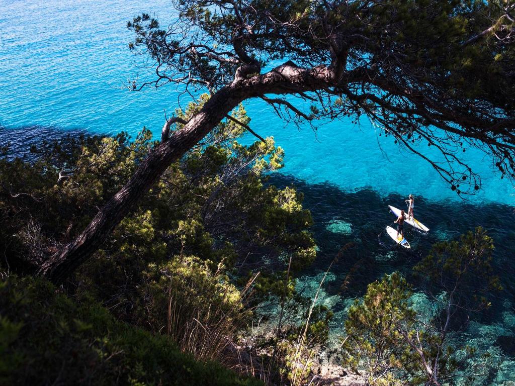 a person on a kayak in the water near the ocean at Las Gaviotas Suites Hotel & Spa in Playa de Muro