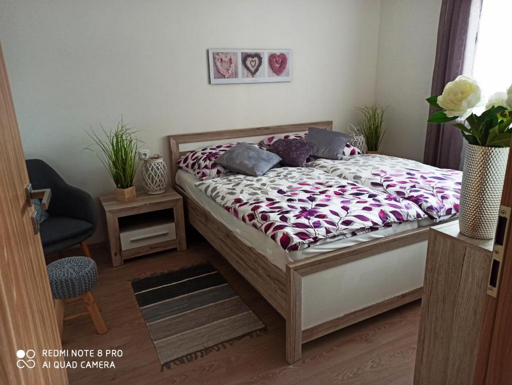 a bedroom with a bed and a table and a chair at Familly Apartmens in Dolní Dunajovice