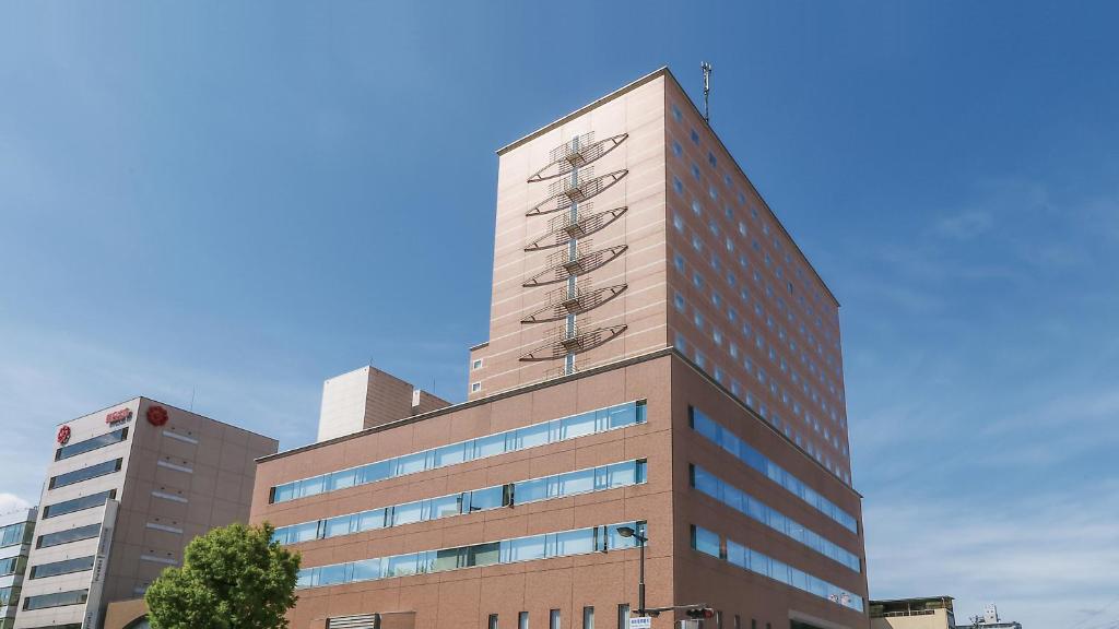 a tall building with a blue sky in the background at Hotel Sankyo Fukushima in Fukushima