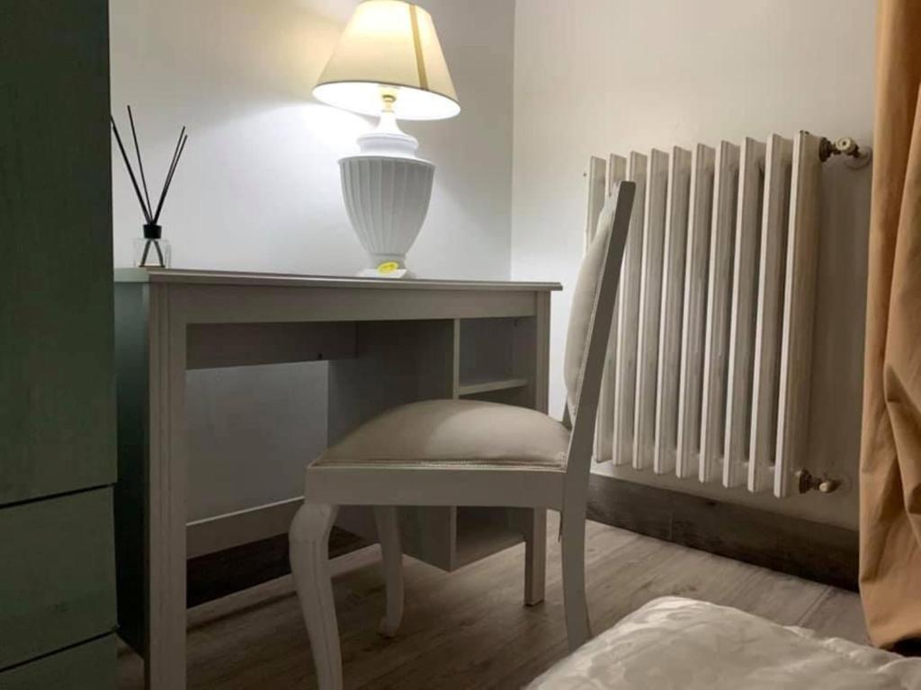 a desk with a lamp and a chair and a table with a lamp at Albergo Lamanna in Taranto