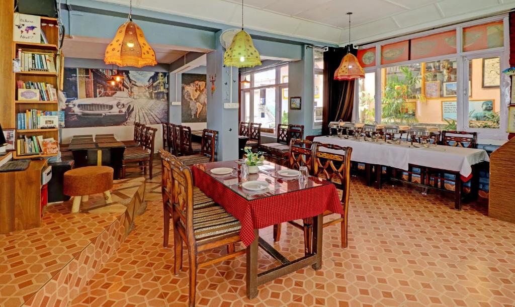 a dining room with a table and chairs in a restaurant at Sky Pie hotel in Dharamshala