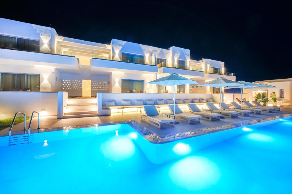 um hotel com uma piscina com cadeiras e guarda-sóis em Narciso Thassos Luxury Suites em Prinos