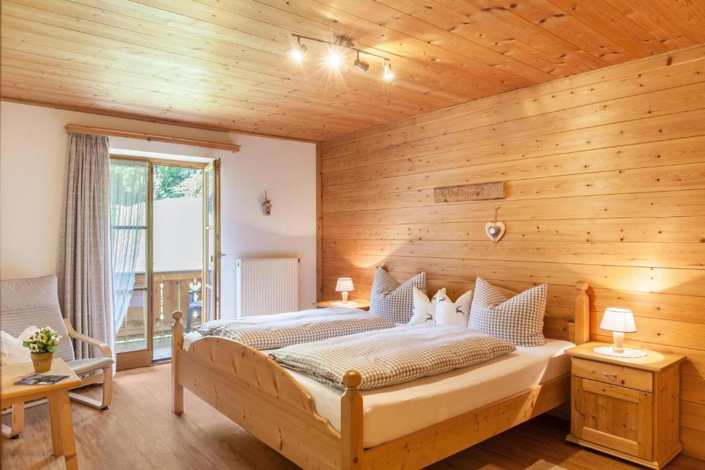 a bedroom with a large bed in a wooden wall at Ferienwohnung Alpenrose in Grainau