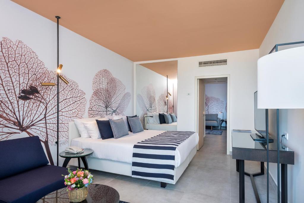 ein Hotelzimmer mit einem Bett und einer Couch in der Unterkunft Yam Suf by Isrotel Collection in Eilat