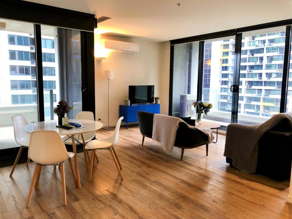 a living room with a table and chairs at ReadySet Apartments on Spencer in Melbourne