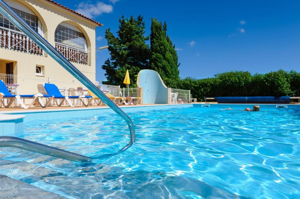 a swimming pool at a resort with blue chairs at Villa Welwitshia in Carvoeiro