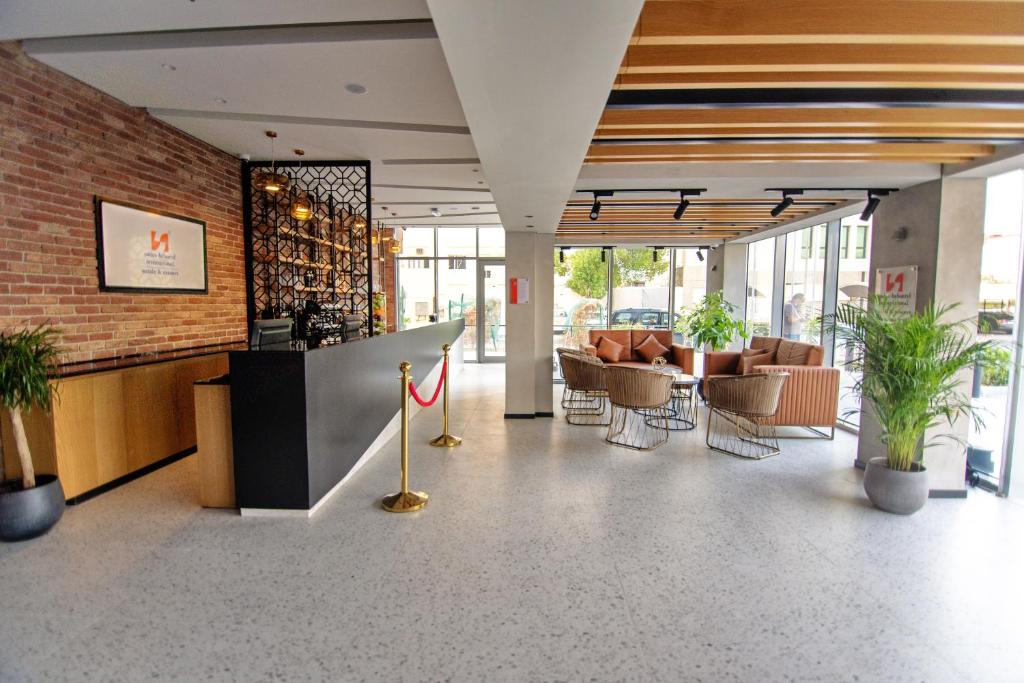 un hall avec des chaises et un bar dans un bâtiment dans l'établissement Swiss-Belinn Sharq, Kuwait, à Koweït