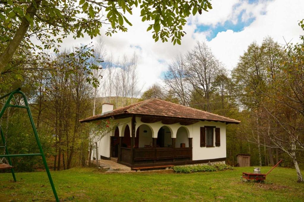 una piccola casa in un cortile con un'altalena di Vikend kuca Mir a Despotovac