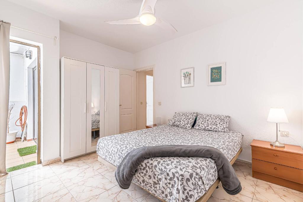 a white bedroom with a bed and a dresser at alquilaencanarias El Medano Playa El Cabezo in El Médano