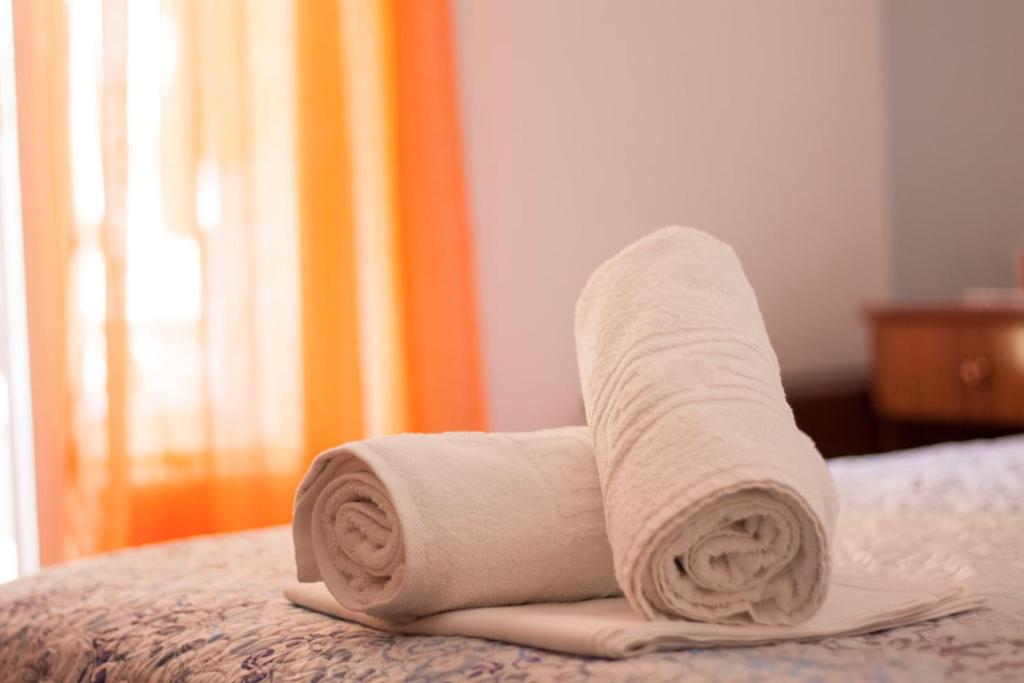 a roll of towels sitting on a bed at Hotel Maria in Skala Potamias