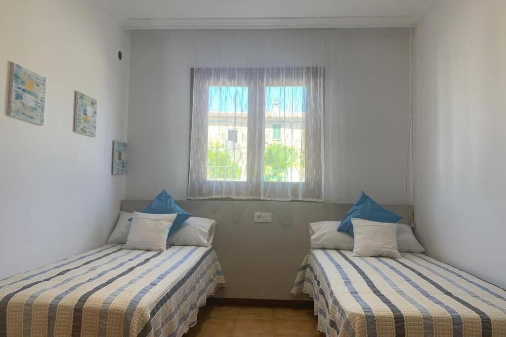 two beds in a room with a window at CASA PISCINA DOCTOR FLEMING 51 in Llubí