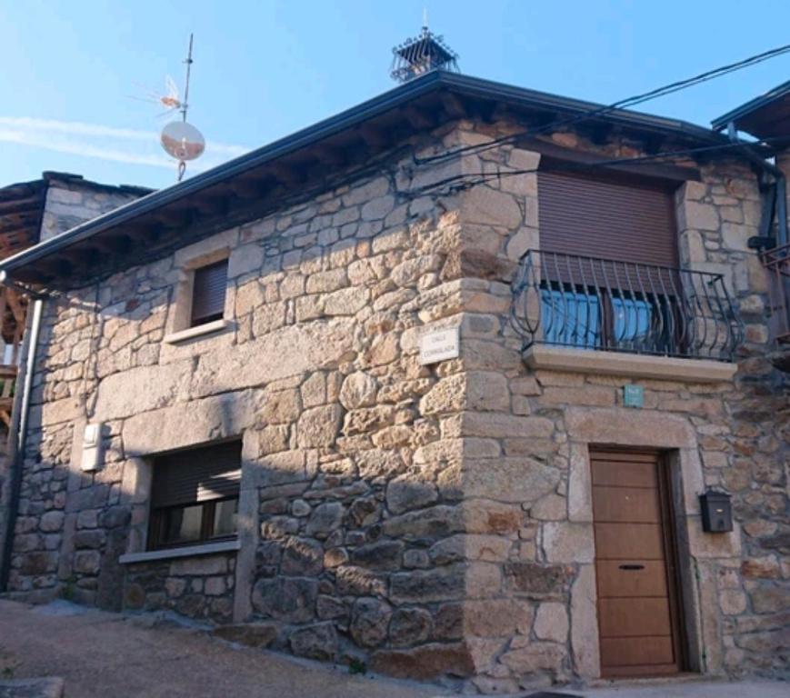 Edificio de piedra con puerta y balcón en La Cantina, en Chanos