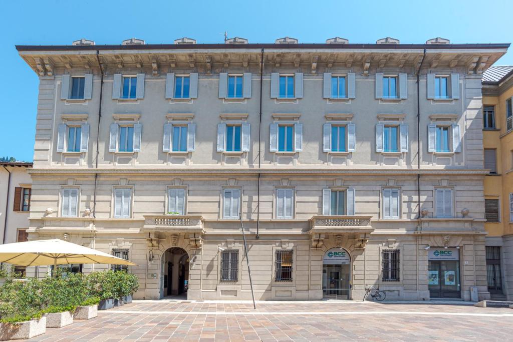 un gran edificio de piedra con ventanas azules en Suite del Cardinale by MyHomeInComo, en Como