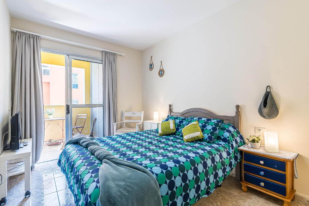 1 dormitorio con 1 cama con edredón azul y blanco en Alquilaencanarias-El Medano Delfines-2 rooms en El Médano